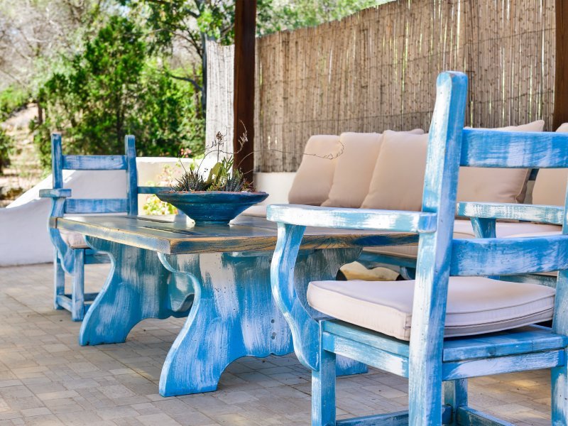 Terrasse mit rustikaler Sitzgruppe aus Holz in sardischem Stil Terrasse mit rustikaler Sitzgruppe aus Holz in sardischem Stil