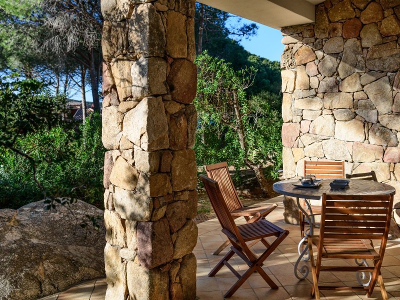 Überdachte Terrasse mit Esstisch umgeben von Pinien Überdachte Terrasse mit Esstisch umgeben von Pinien