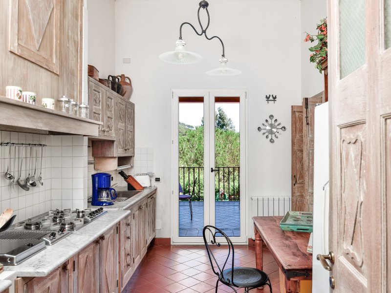 Vollausgestattete Küche mit kleinem Esstisch und Terrassenzugang