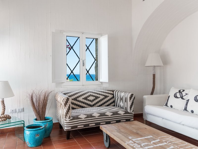 Wohnzimmer mit gemütlicher Sofaecke und Fenster mit Meerblick