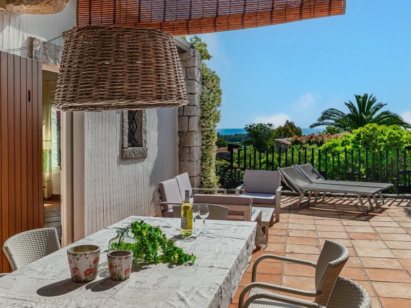 Terrasse mit Blick in den Garten und in der Ferne aufs Meer