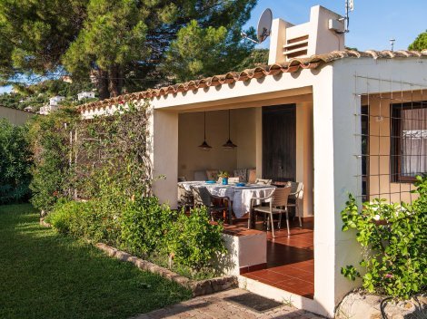 Außenbereich mit Garten und überdachter Terrasse mit großem Esstisch